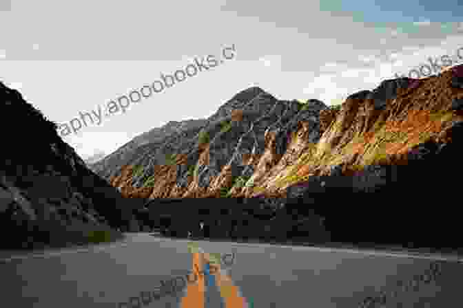 A Stunning Landscape View Of A Bus Winding Through A Scenic Road Amidst Mountains And A Lake Buses Of Skye And The Western Isles